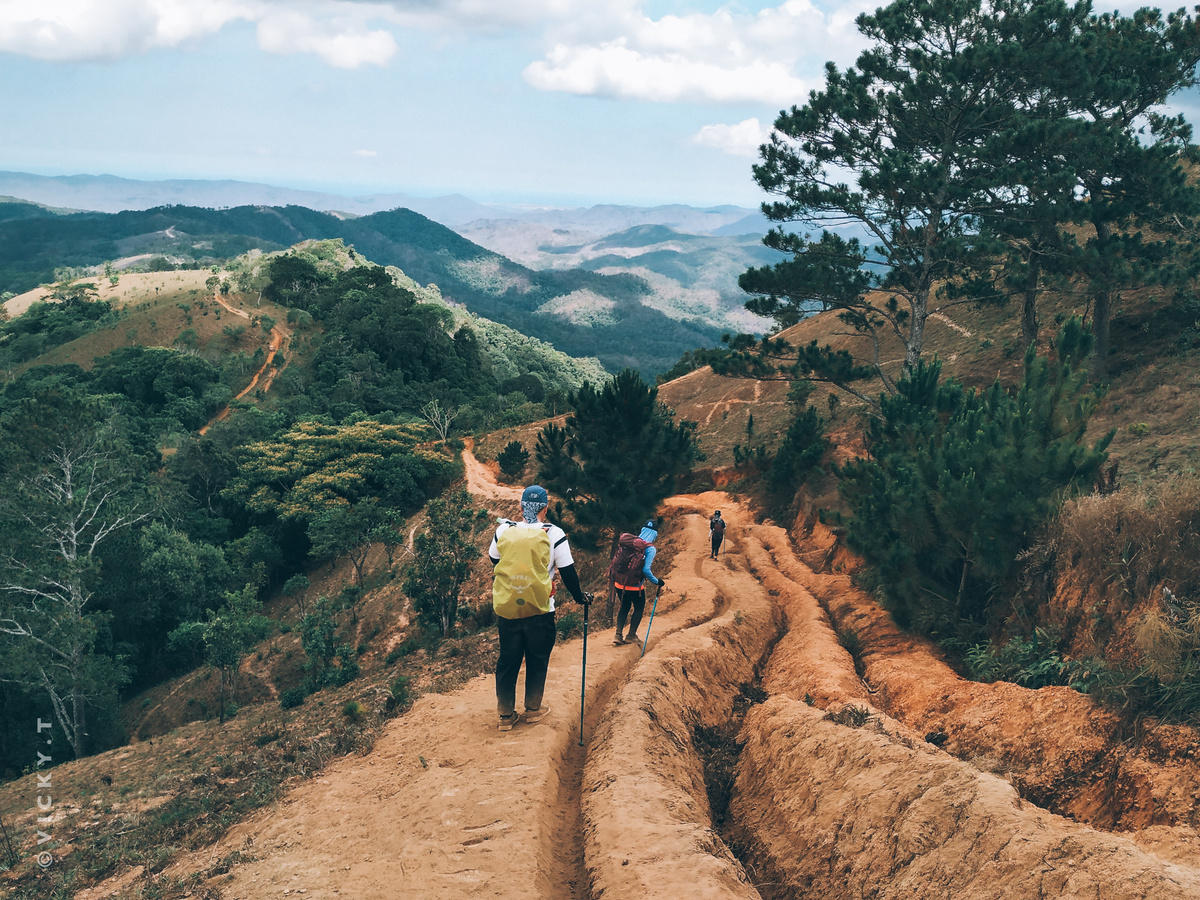 Tourists walking along path in mountainous terrain